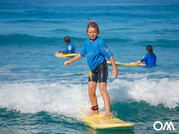 Drei Kinder im Wasser beim Kindersurfkurs