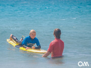 Kindersurfkurs, Surflehrer mit Kind im Wasser