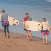Drei Kinder mit Surfboards am Strand