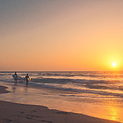Surfer am Strand beim Sonnenuntergang