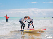 Zwei Kinder surfen gemeinsam eine Welle