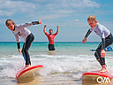 Kinder teilen sich Welle bei Surfkurs